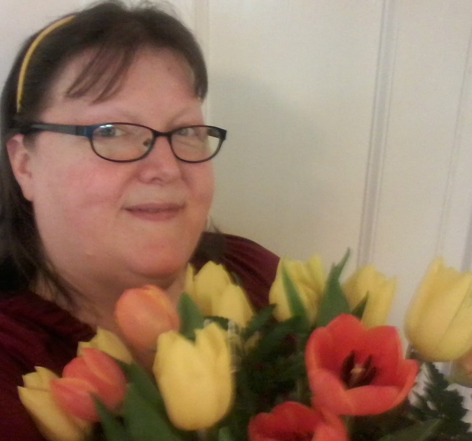 image: Carolyn Cates holding bright yellow and orange tulips